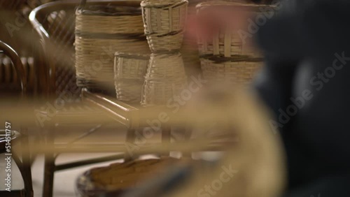 male worker weaving wicker baskets in the workshop where handmade wicker baskets are produced