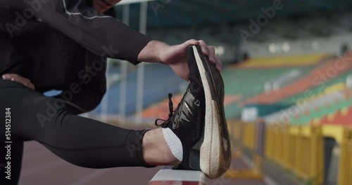 Athlete stretching before training on stadium photo