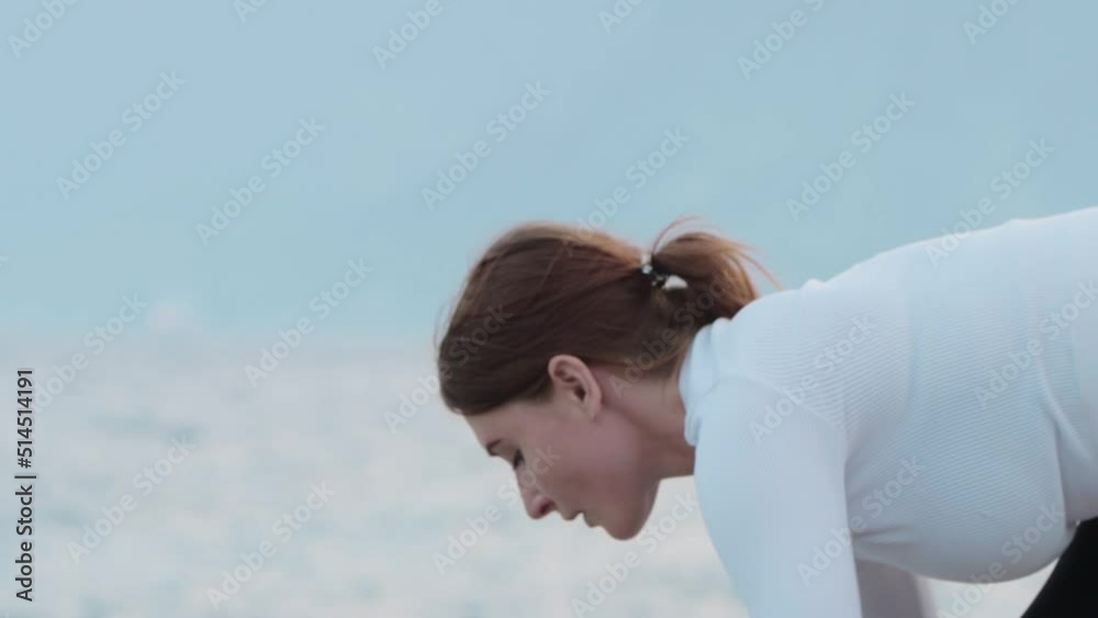 Sports outdoors - a young fitness woman stretching by the sea Sports outdoors - a young fitness woman stretching by the sea
