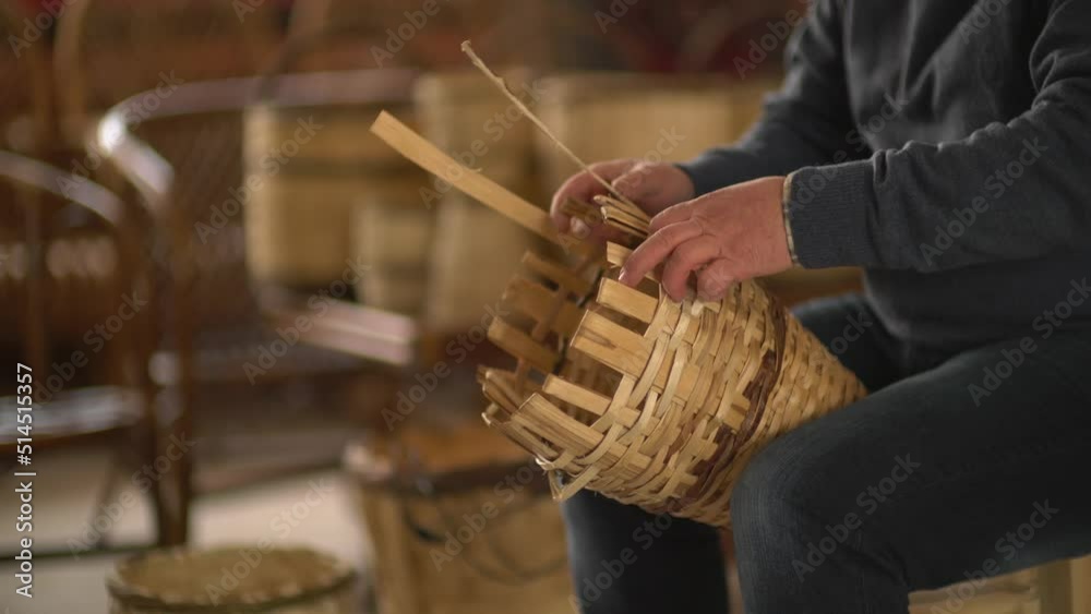 male worker weaving wicker baskets in the workshop where handmade wicker baskets are produced