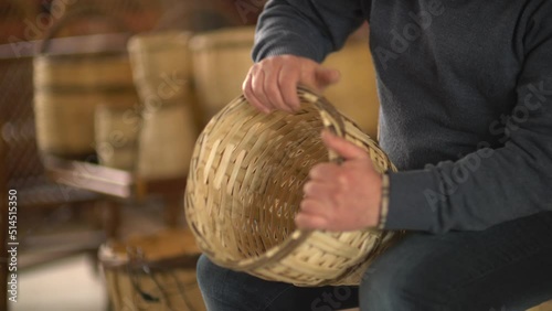 male worker weaving wicker baskets in the workshop where handmade wicker baskets are produced