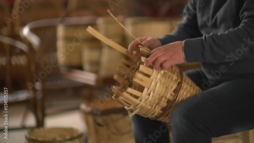male worker weaving wicker baskets in the workshop where handmade wicker baskets are produced
