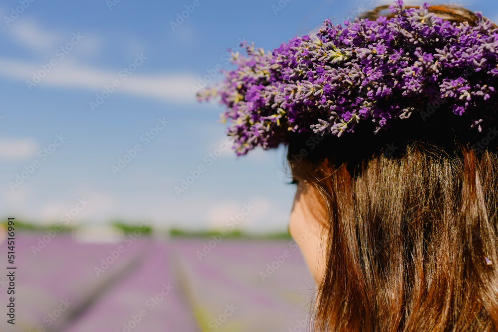 Naklejka premium Woman with wreath of flowers in lavender field