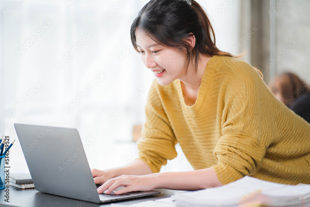 Smiling asian business woman sitting in a modern office Smiling asian business woman sitting in a modern office
