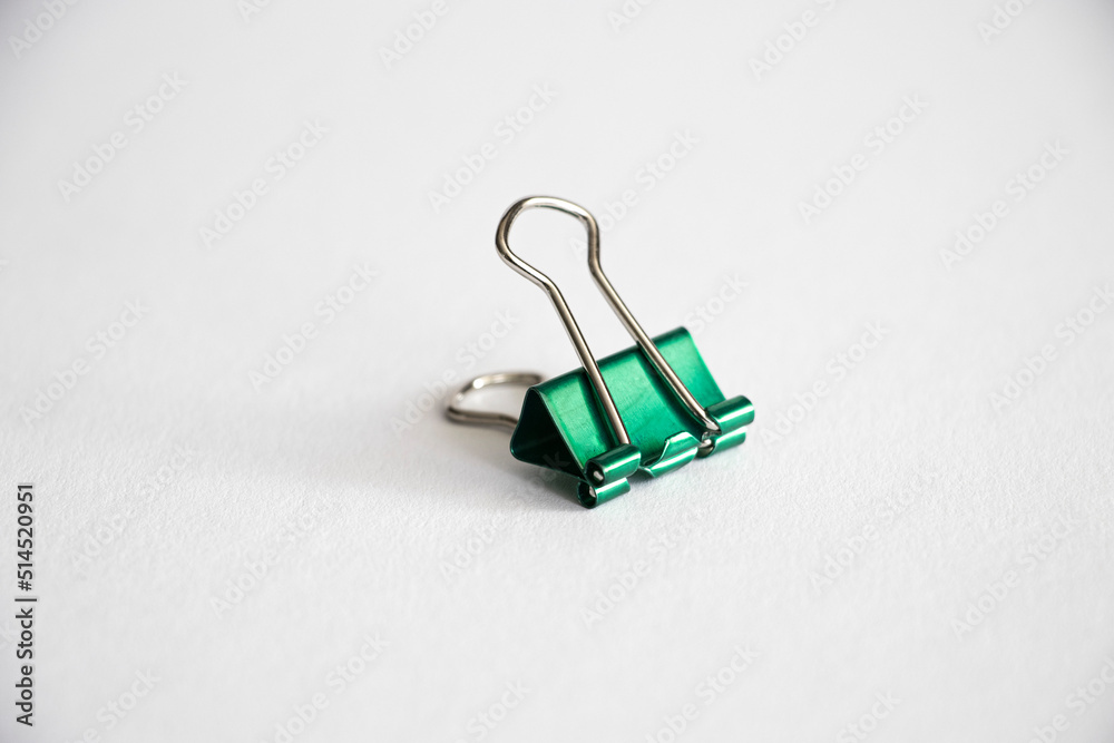 a piece of green office binder clip a piece of green office binder clip