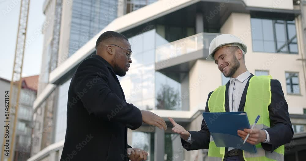 Male developer giving keys to owner at building site Male developer giving keys to owner at building site