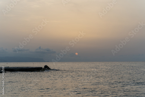 Sonnenuntergang am Meer in Italien. Vielfalt der Farben und Farben der aufgehenden Sonne. Meereslandschaft mit Wasser und Steinen.