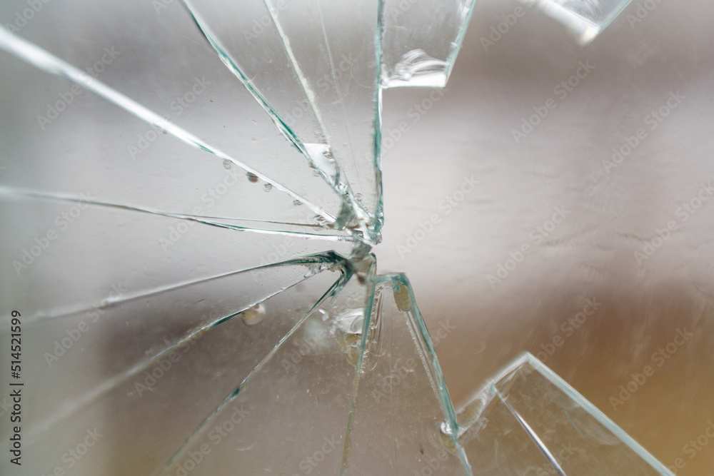 Glass broken by hooligans in a metal-plastic window, close-up Glass broken by hooligans in a metal-plastic window, close-up