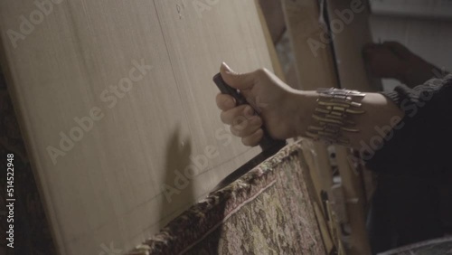 woman weaving a handmade carpet close-up