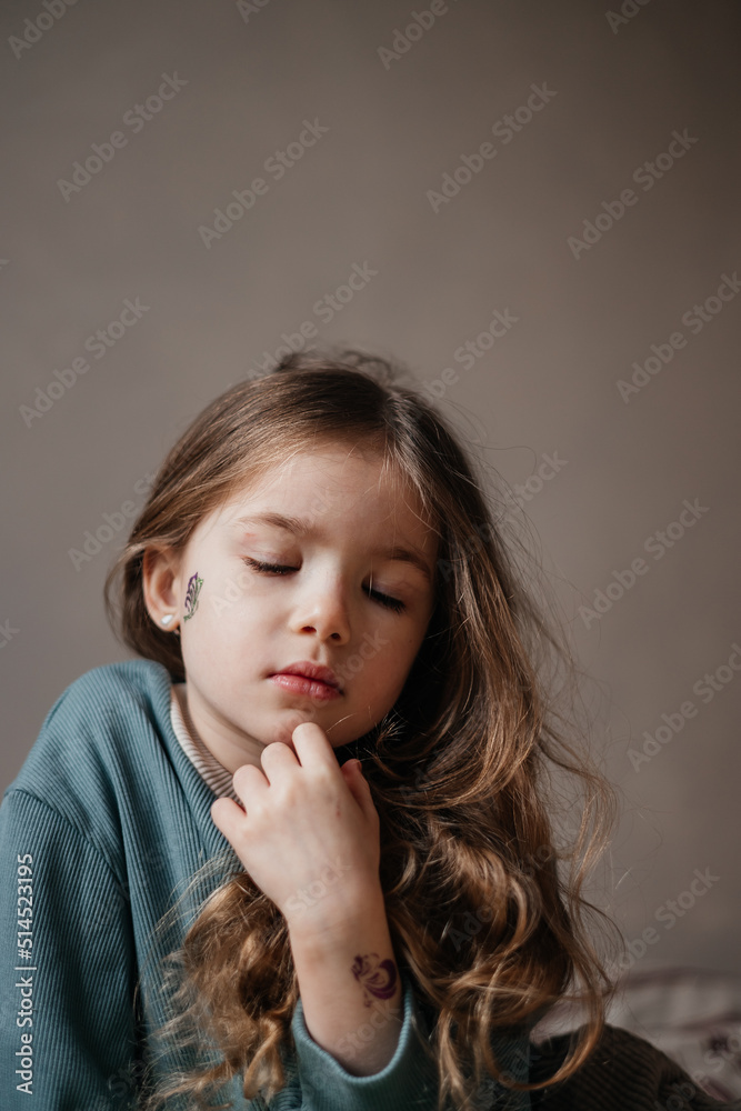 Portrait of a 4-year-old girl holding a bouquet of fresh pink tulips posing for a photo with morning light Portrait of a 4-year-old girl holding a bouquet of fresh pink tulips posing for a photo with morning light
