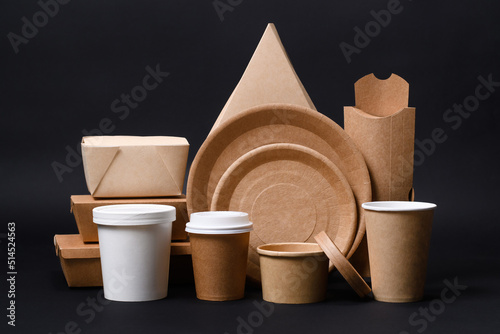 A set of disposable eco-friendly paper utensils on a dark background. The concept of using biodegradable materials photo