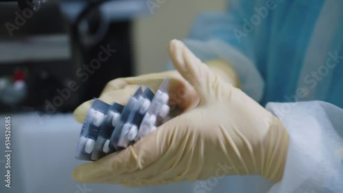 A pharmaceutical production worker checks the packaging of medicines on the production line. close-up