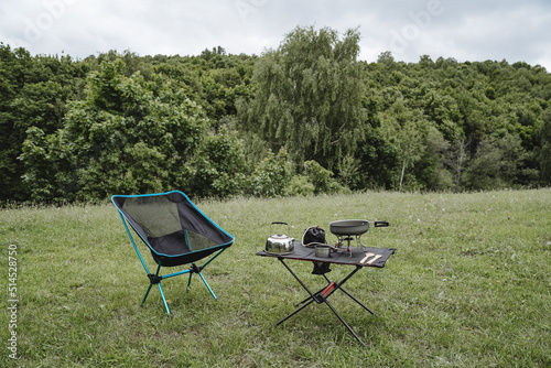 The concept of a tourist holiday in the wild, camping in a clearing in the forest, hiking, a summer vacation in a hike, compact equipment, a folding chair.