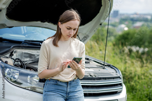Slika na platnu Young woman opening bonnet of broken down car having trouble with her vehicle