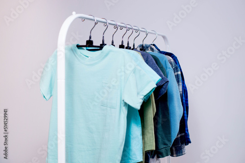 Rack with stylish children's clothes on hangers for a preschool boy. Wardrobe for a little boy