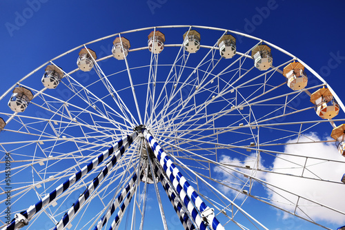 ferris wheel of the amusement park in the blue sky background. Retro colorful ferris wheel of the amusement park in the blue sky background.