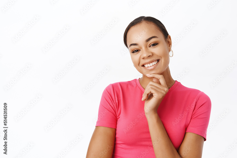 Close up of smiling beautiful woman, looking healthy and happy, standing in pink tshirt over white studio background Close up of smiling beautiful woman, looking healthy and happy, standing in pink tshirt over white studio background