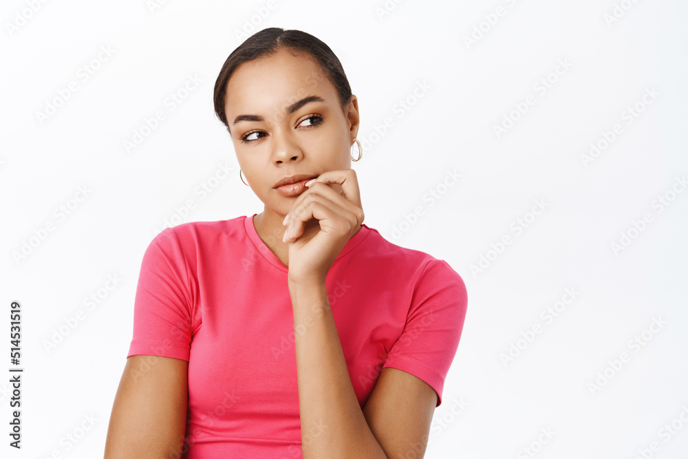 Image of thoughtful girl, looking aside and planning smth in her head, thinking, standing over white background Image of thoughtful girl, looking aside and planning smth in her head, thinking, standing over white background