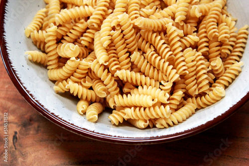 fusilli pasta in a bowl on a wooden table