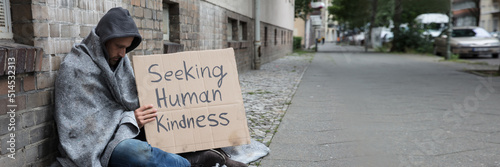 Beggar Showing Seeking Human Kindness Sign On Cardboard