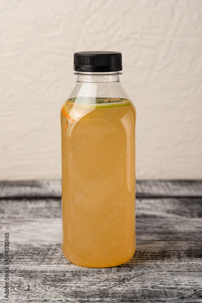 Lemonade, homemade lemonade in a bottle, on a white wooden background Lemonade, homemade lemonade in a bottle, on a white wooden background