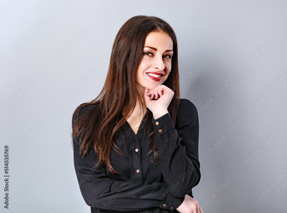 Beautiful thinking happy smiling business woman with toothy smile in black shirt on grey blue background with empty copy space. Closeup Beautiful thinking happy smiling business woman with toothy smile in black shirt on grey blue background with empty copy space. Closeup