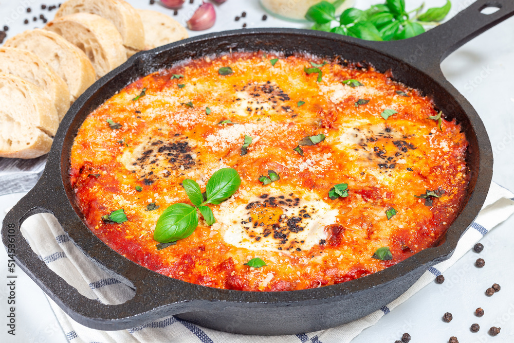 Shakshuka with eggs, Italian sausage, tomato sauce, in cast iron pan, horizontal Shakshuka with eggs, Italian sausage, tomato sauce, in cast iron pan, horizontal