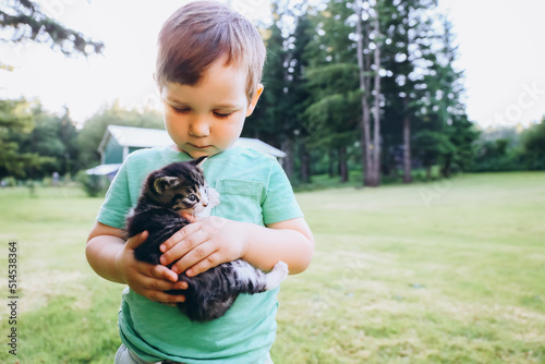 Little boy with kitten in his hands, outdoor