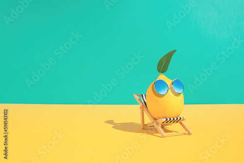 Lemon fruit chilling in beach chair on the blue and yellow background Fototapeta