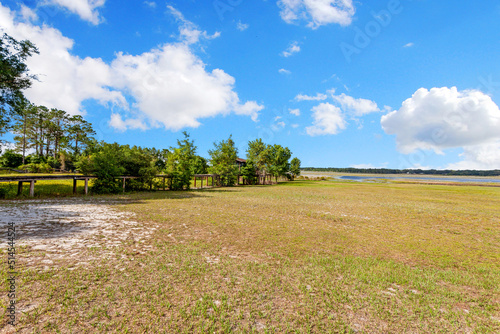 Large grassy field with small lake in background
