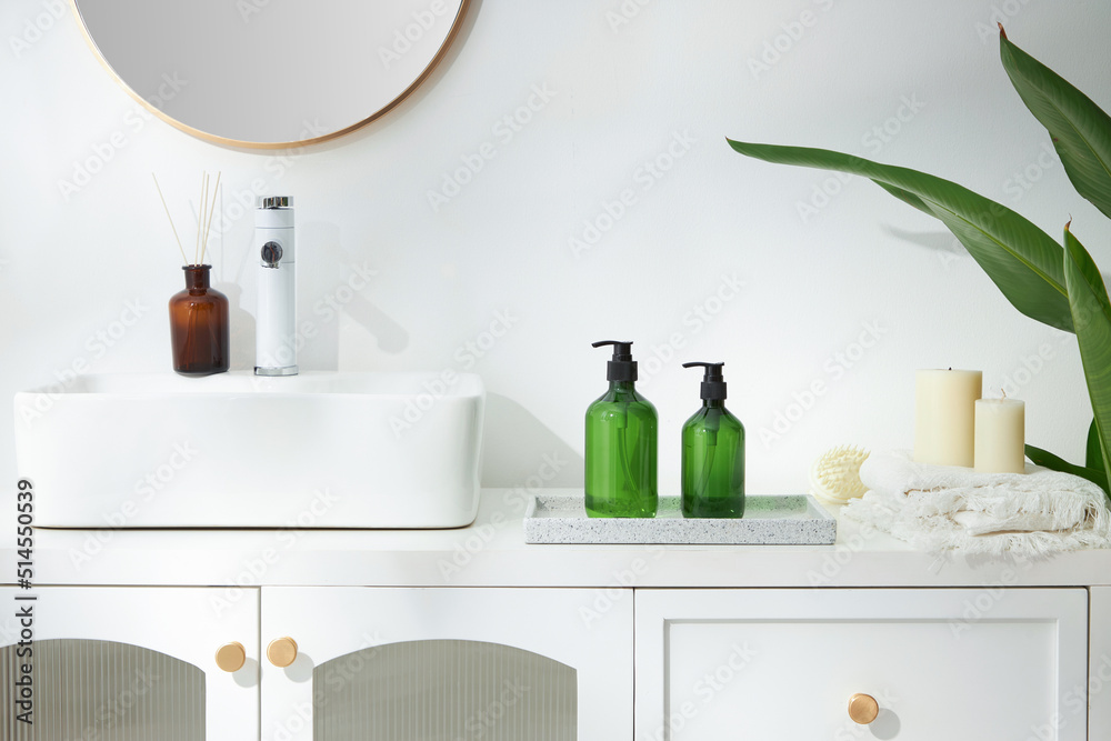 Cosmetics product and cotton towels, cottons pad with green plant on white table inside a bathroom background ceramic. Cosmetics product and cotton towels, cottons pad with green plant on white table inside a bathroom background ceramic.
