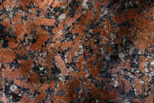 Red and black polished granite slab. Sunlight. Copy space. 