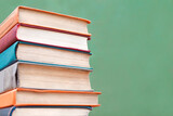 a stack of colorful books close-up on a blackboard background