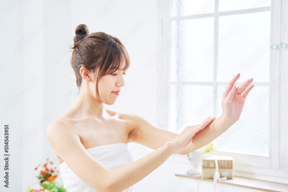 リビングで腕のケアをする女性