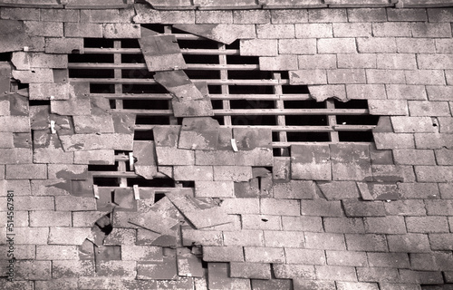 Derelict barn in English countryside. Section of brick wall collapse. Wooden struts exposed. photo taken 1998. Black and white film. Scanned negative.