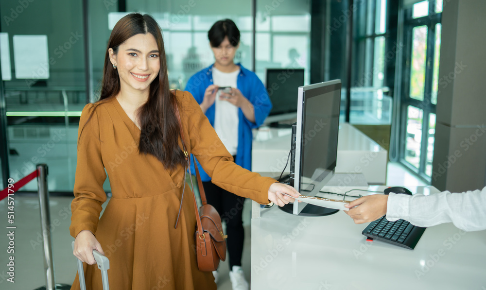 Young business woman at check-in counter with airlines staff. Airline transportation and tourism concept. Young business woman at check-in counter with airlines staff. Airline transportation and tourism concept.