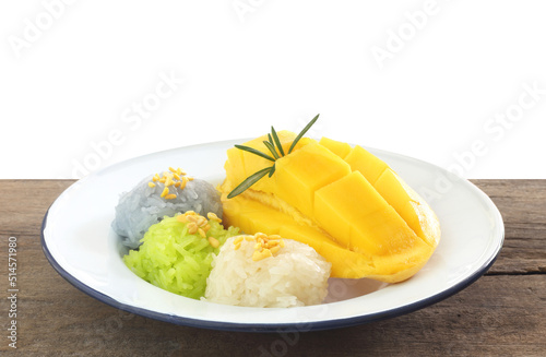 Fototapeta Naklejka Na Ścianę i Meble -  Thai famous dessert - plate of sweet fresh ripe mango with white, gren and purple sticky rice on wooden table against white background