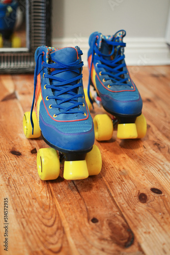 Obraz na płótnie Closeup shot of blue vintage quad roller skates with yellow wheels on wooden floor w salonie