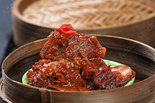 Dimsum, spicy beef ribs. Served on a bamboo bowl and container. blur background