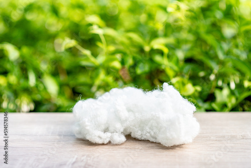 Polyester stable fiber on wooden plank with green blurred background