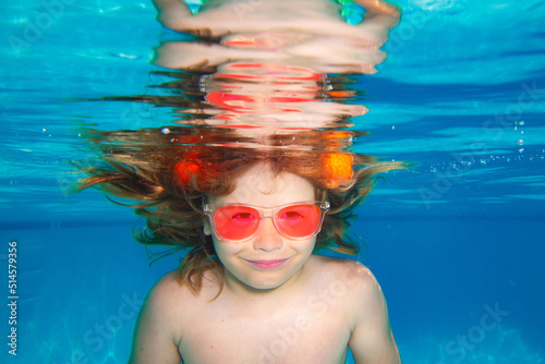Summer kids face. Underwater child swims in pool, healthy child swimming and having fun under water. Underwater children. Summer vacation with child. © Volodymyr