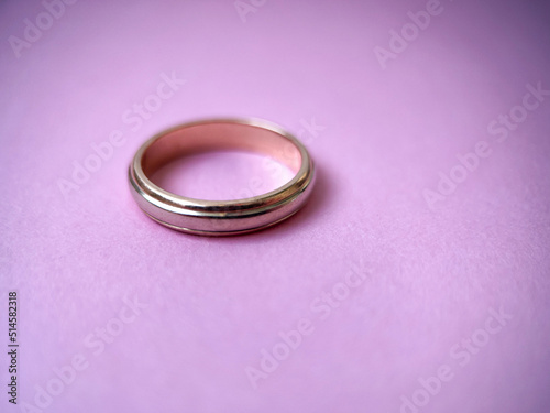 Gold wedding ring on pink isolated background. Red and white gold ring