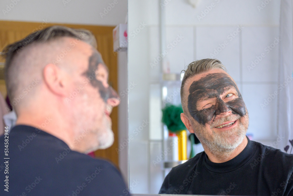 Fototapeta premium Egotistical man smiling and winking at himself in a mirror