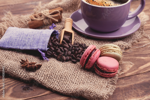 cup of coffee, beans, cinnamon, macaroons and anise on the wooden background Coffee is the good idea