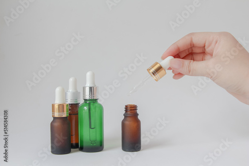 Woman hands holding facial essential oil or serum packaging on white background. Beauty cosmetic product for skincare concept.