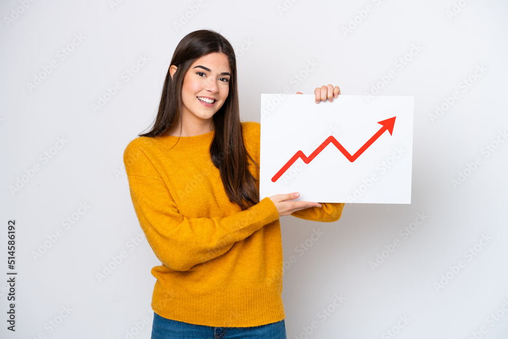 Young Brazilian woman isolated on white background holding a sign with a growing statistics arrow symbol Young Brazilian woman isolated on white background holding a sign with a growing statistics arrow symbol
