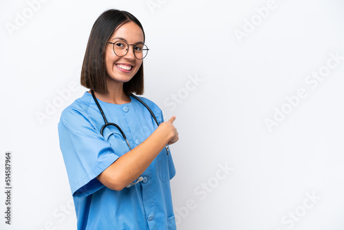 Young surgeon doctor woman isolated on white background pointing back