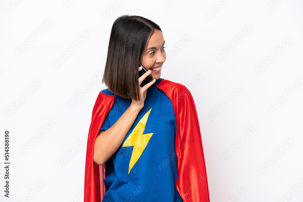 Super Hero caucasian woman isolated on white background keeping a conversation with the mobile phone with someone