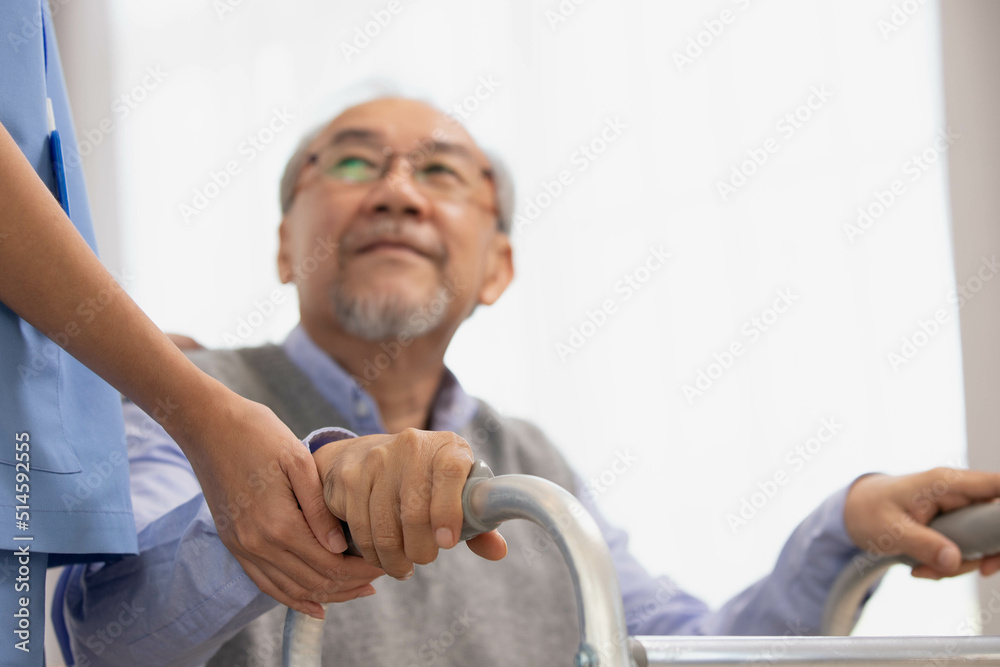 Close up.Asian nurse holding an elderly man with a walking stick for physiotherapy. Close up.Asian nurse holding an elderly man with a walking stick for physiotherapy.