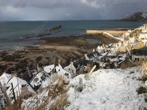 Scottish village of Gardenstown in the snow with winter sunlight